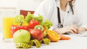 nutritionist desk with fruits and measuring tape
